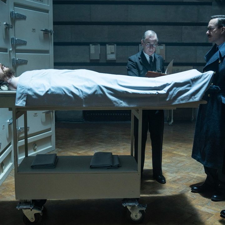 Two British officers stare at a corpse inside a morgue in a scene from Operation Mincemeat.