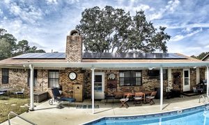 A modest house, pool and tree.