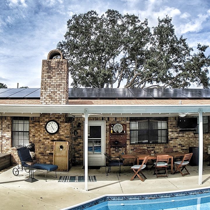 A modest house, pool and tree.