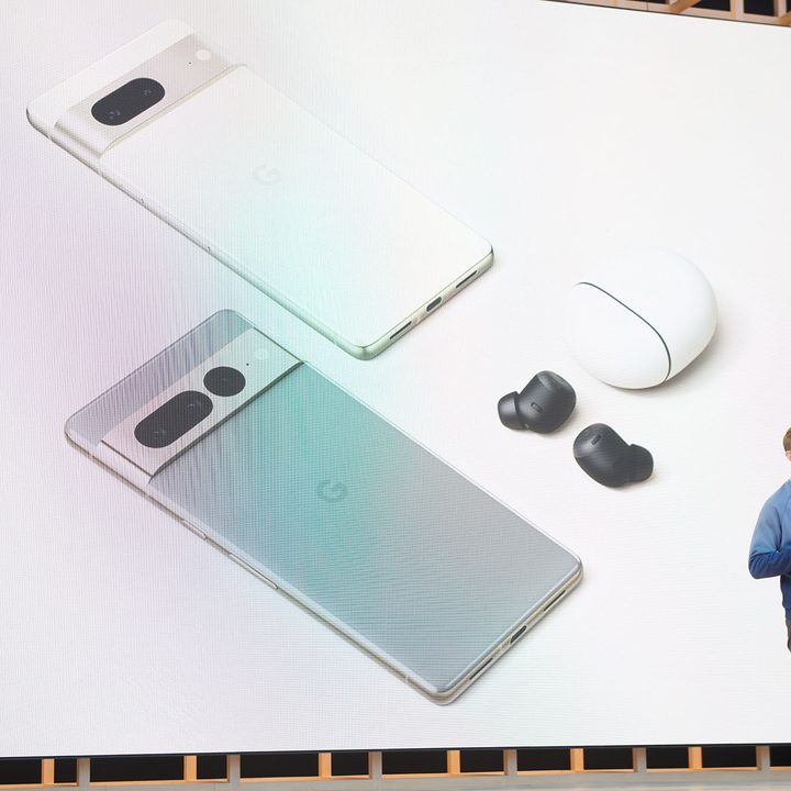 A man stands on stage in front of a Pixel 7 and 7 Pro graphic.