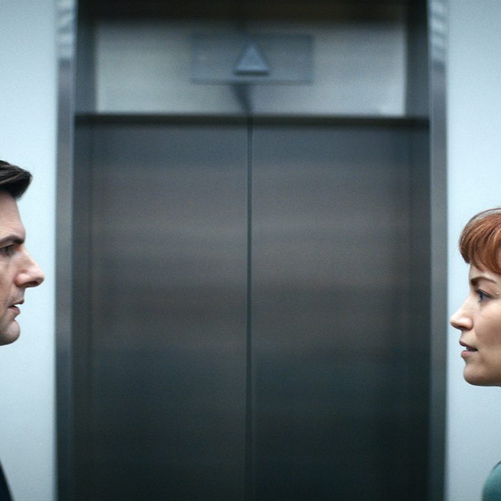 Mark and Helly looking at one another in front of the elevator at work in Apple TV+ series Severance.