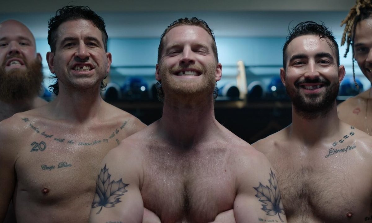 The men of Shoresy smile at the camera, shirtless, with missing teeth.