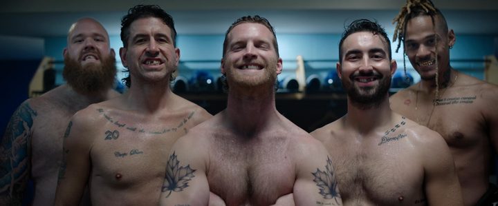 The men of Shoresy smile at the camera, shirtless, with missing teeth.
