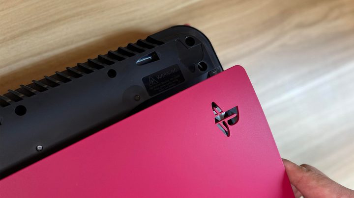 The PS5 engraving on the console is being aligned with the cutout on the new top cover.