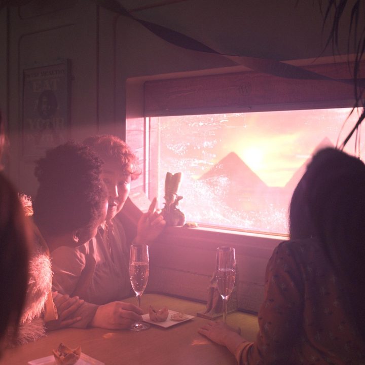 An image of people looking out a train window at snow-covered pyramids from the Snowpiercer series.