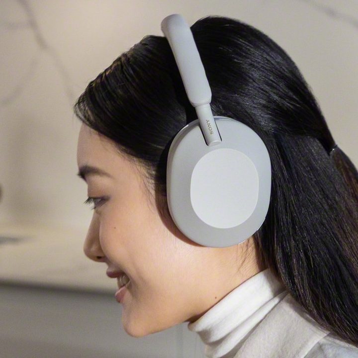 Woman wearing Sony WH-1000XM5 headphones.
