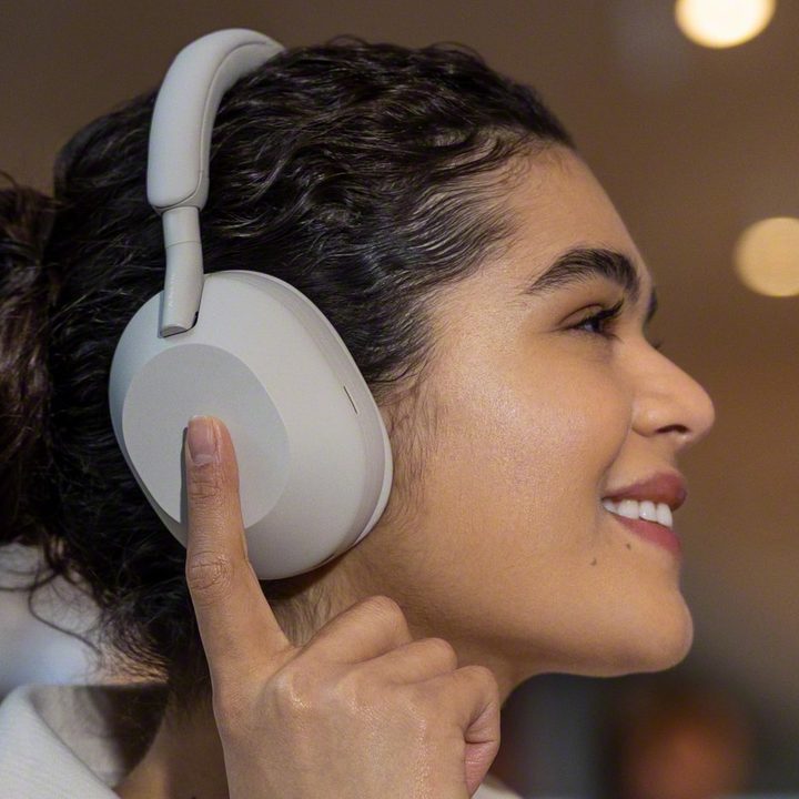 Woman wearing Sony WH-1000XM5 headphones.