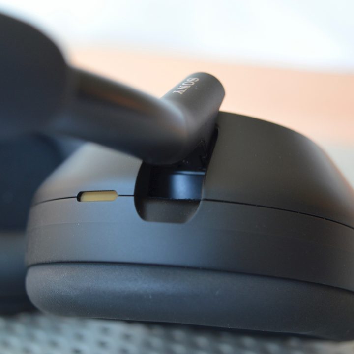 Close-up of earcup-pivot on Sony WH-1000XM5 wireless headphones.