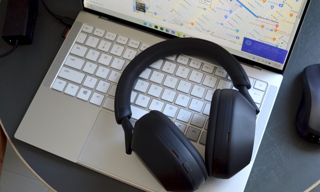 Sony WH-1000XM5 wireless headphones sitting on a laptop keyboard.