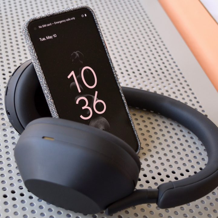 Sony WH-1000XM5 wireless headphones seen with a smartphone.