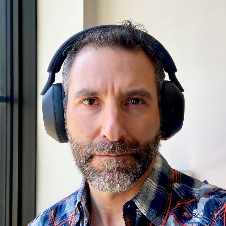 Front view of man wearing Sony WH-1000XM5 wireless headphones.