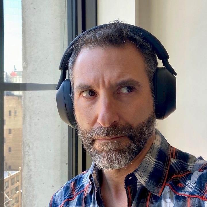 Front view of man wearing Sony WH-1000XM5 wireless headphones.