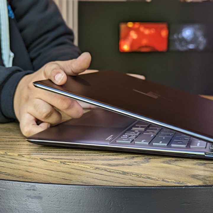 A man holding the Spectre x360 13.5 in his hands showing the side profile.