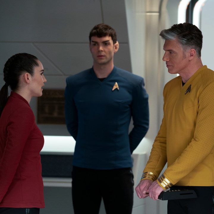 Christina Chong, ethan Peck, and Anson Mount talk while standing in a room of the USS Enterprise in a scene from Star Trek: Strange New Worlds.