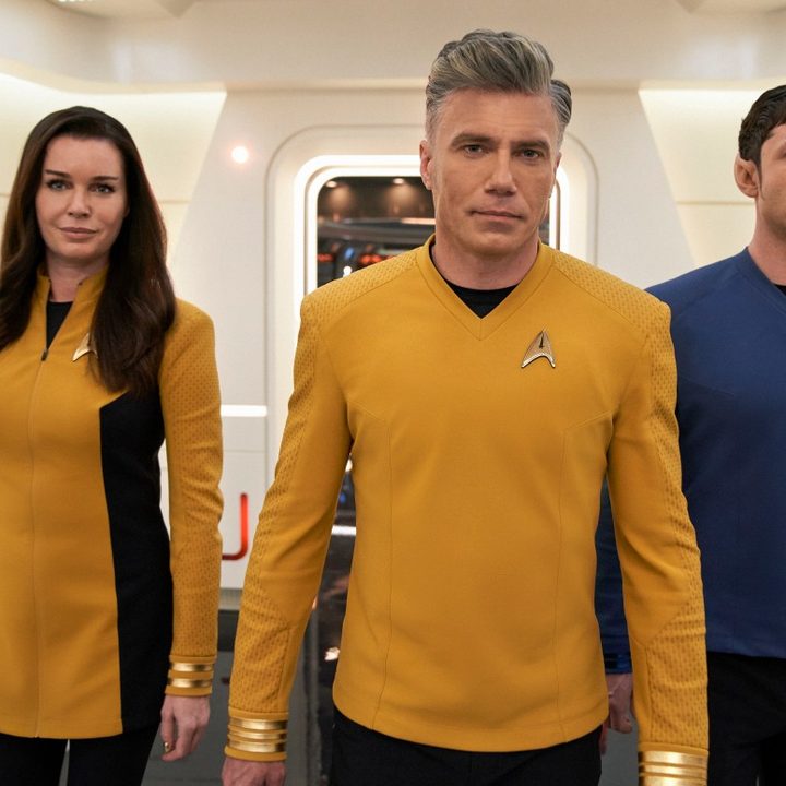 Rebecca Romijn, Anson Mount, and Ethan Peck walk in the hallway of the USS Enterprise in a scene from Star Trek: Strange New Worlds.