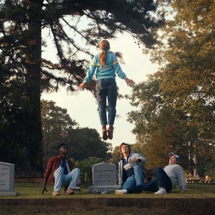Sadie Sink's character levitates over a group of characters in a scene from Stranger Things 4.