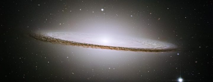 NASA's Hubble Space Telescope has trained its razor-sharp eye on one of the universe's most stately and photogenic galaxies, the Sombrero galaxy, Messier 104 (M104). The galaxy's hallmark is a brilliant white, bulbous core encircled by the thick dust lanes comprising the spiral structure of the galaxy. As seen from Earth, the galaxy is tilted nearly edge-on. We view it from just six degrees north of its equatorial plane. This brilliant galaxy was named the Sombrero because of its resemblance to the broad rim and high-topped Mexican hat.