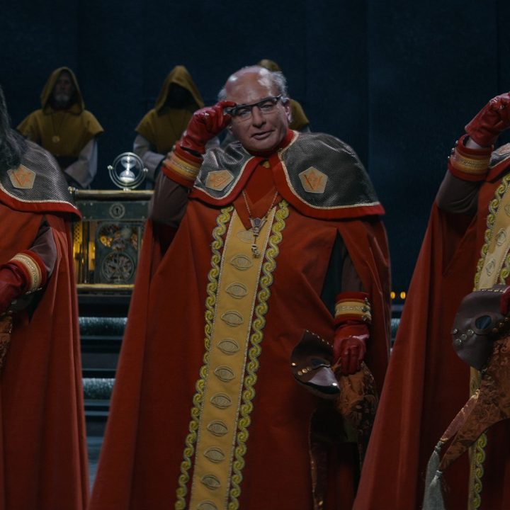 Mike Myers plays three members of The Pentaverate, saluting the camera, in a scene from the Netflix series.