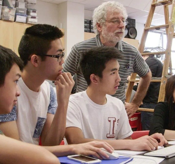 Students sit in front of a computer in try harder!