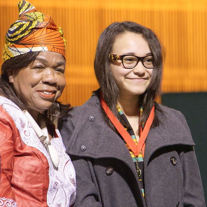 A female teenager stands next to her mother in try harder!