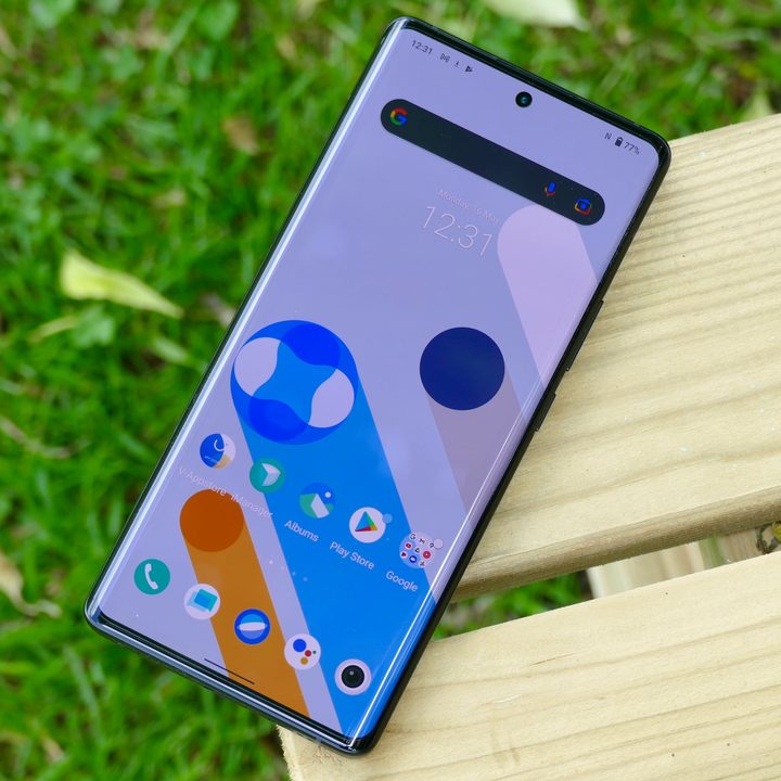 The Vivo X80 Pro's main home screen view, with the phone resting on a bench.