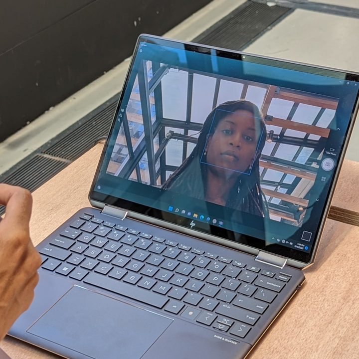 A woman sitting in front of the webcam on the Spectre x360 13.5 inch.