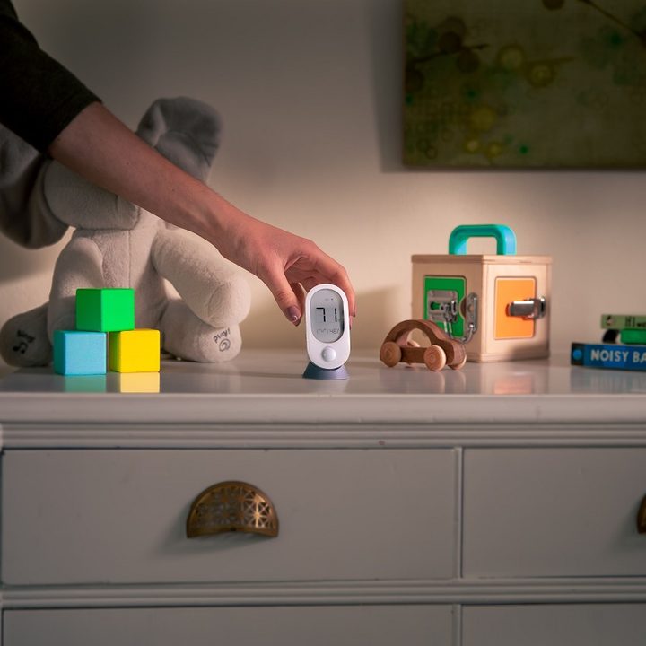 Wyze Room Sensor being placed on a dresser.