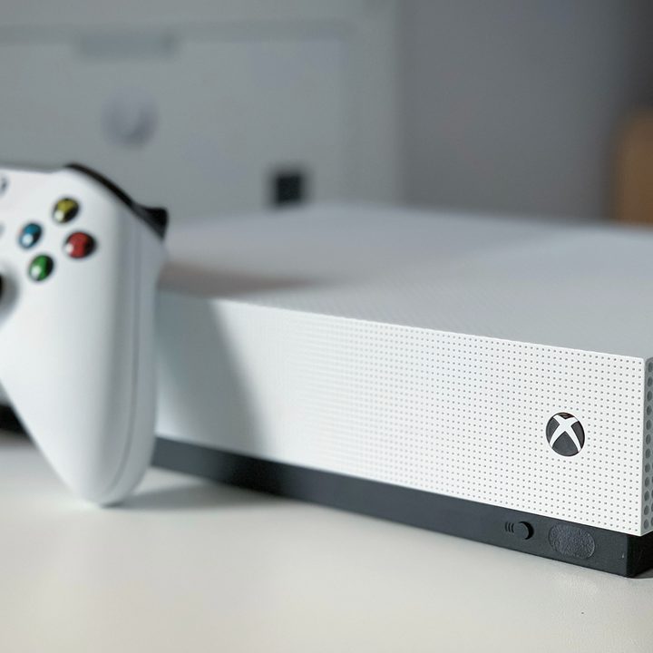 Xbox Series S placed on a white table with the controller just in front of it