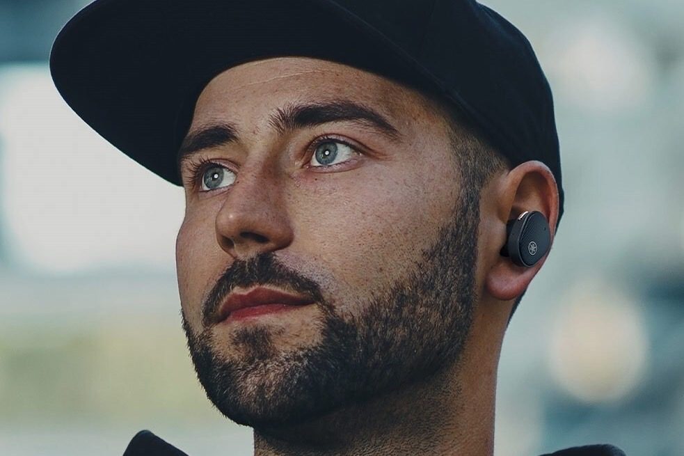 Man wearing Yamaha TW-E5B earbuds in black.