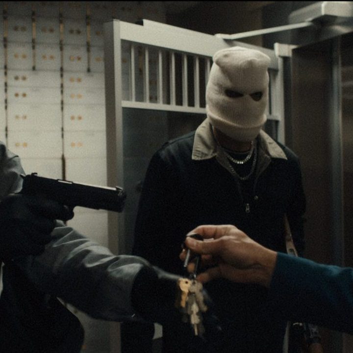 Three bank robbers hold a worker up a at gunpoint in a scene from Blowback.