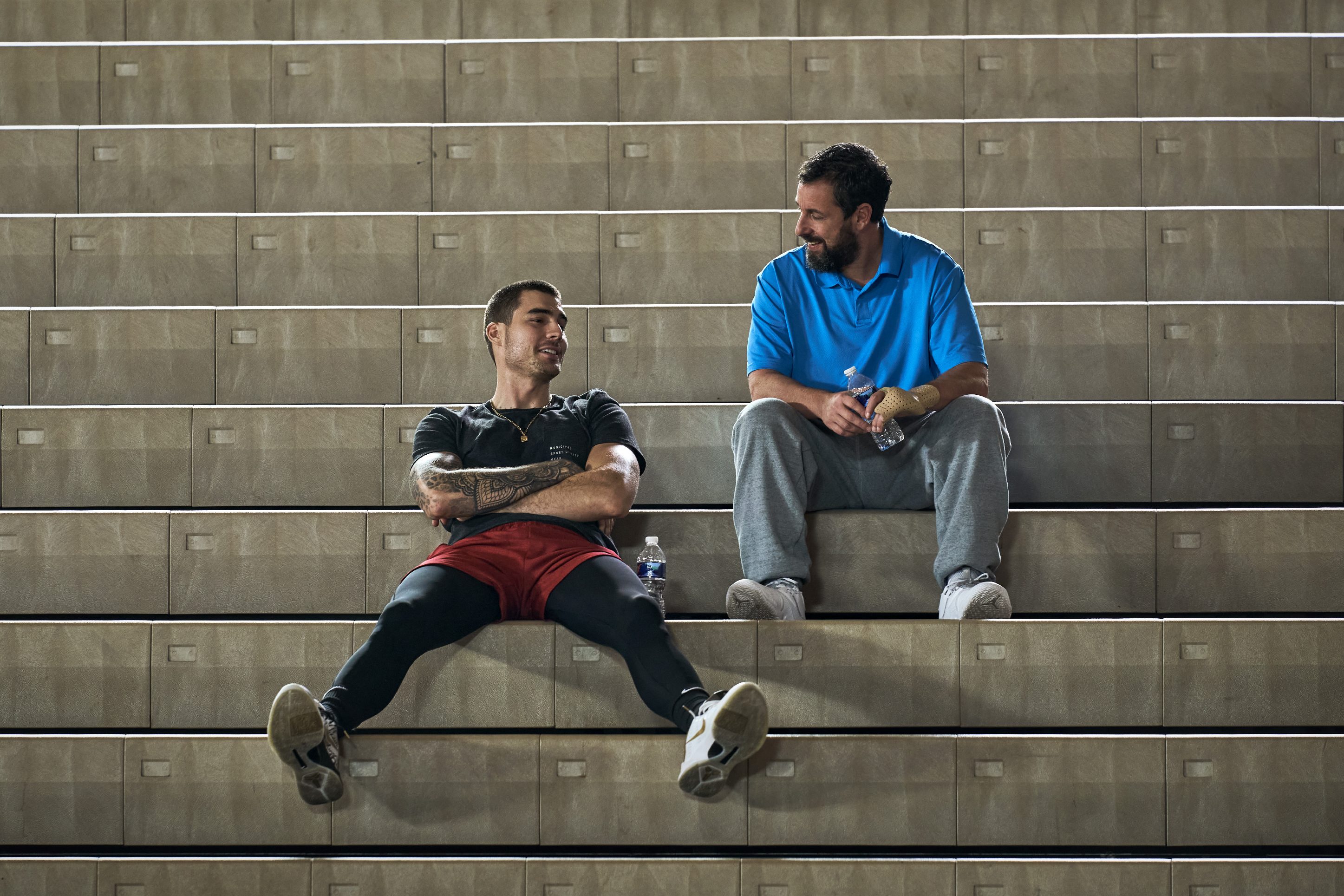 Bo Cruz and Stanley Sugarman sit on bleachers together in Hustle.