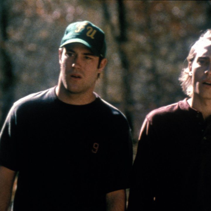 Two characters from the movie Cabin Fever are standing in front of a forest.