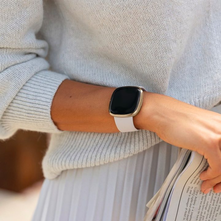 A close up of someone's arm while they use a Fitbit Sense.