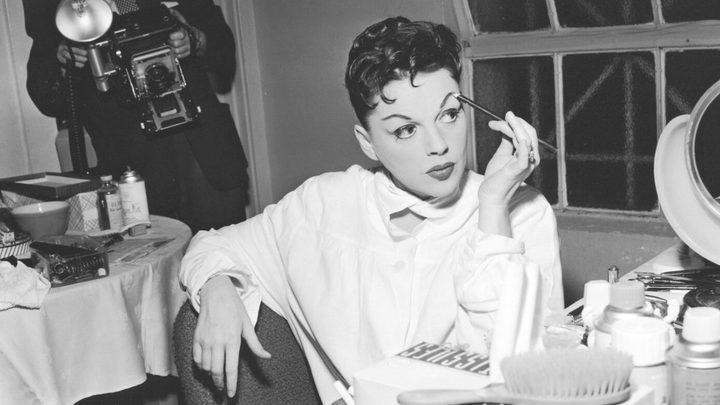 Judy Garland doing her eyebrows in her dressing room.