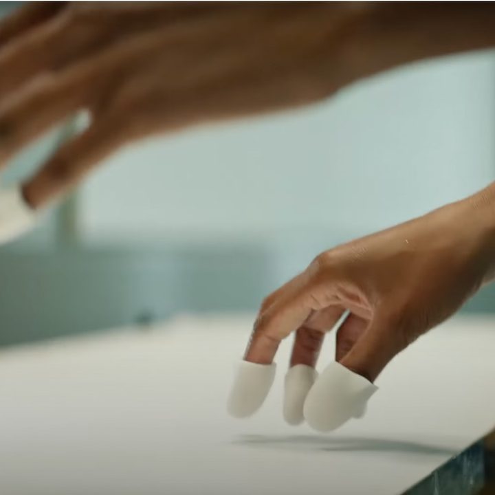 Meta VR fingertip sensors shown on someone's hands.