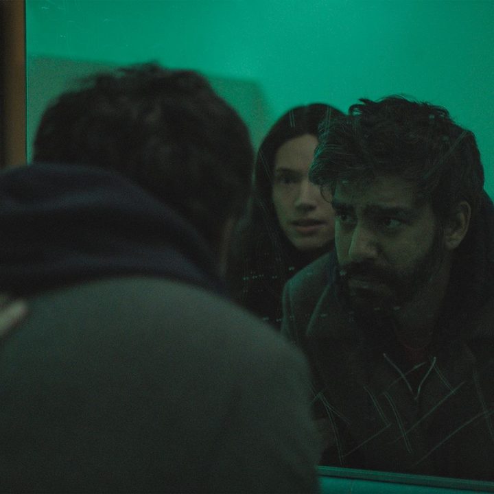 Katie Parker standing behind Rahul Kohli in a bathroom in a scene from Next Exit.