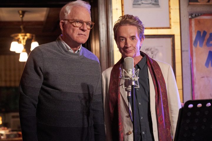 Charles and Oliver stand in front of a microphone in Only Murders in the Building Season 2.