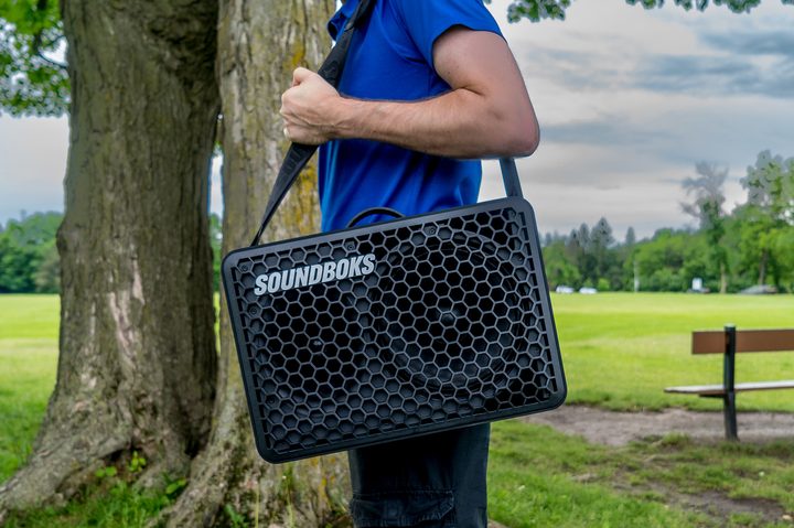 Soundboks Go with carrier strap on shouldder..