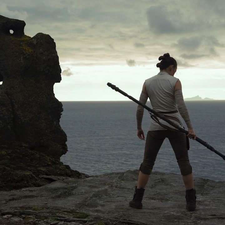 rey poses near a beach on Star wars: The Last Jedi.