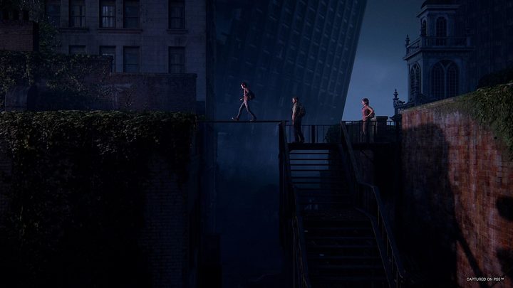 Ellie walks on a board spanning two rooftops.