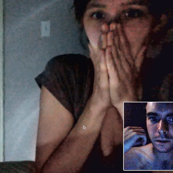 A woman is sitting on a webcam call covering her mouth from the movie VHS.