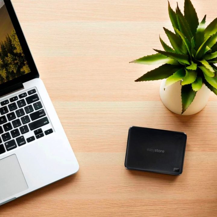 A WD Easystore external hard drive next to a MacBook Pro.