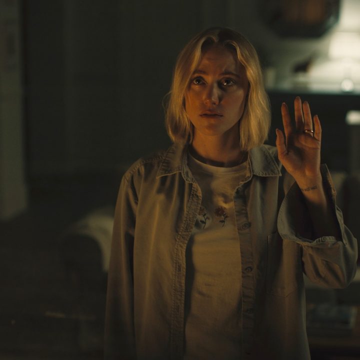 Maika Monroe waves out the window.