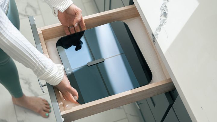 Person storing the Wyze Scale X in a drawer.