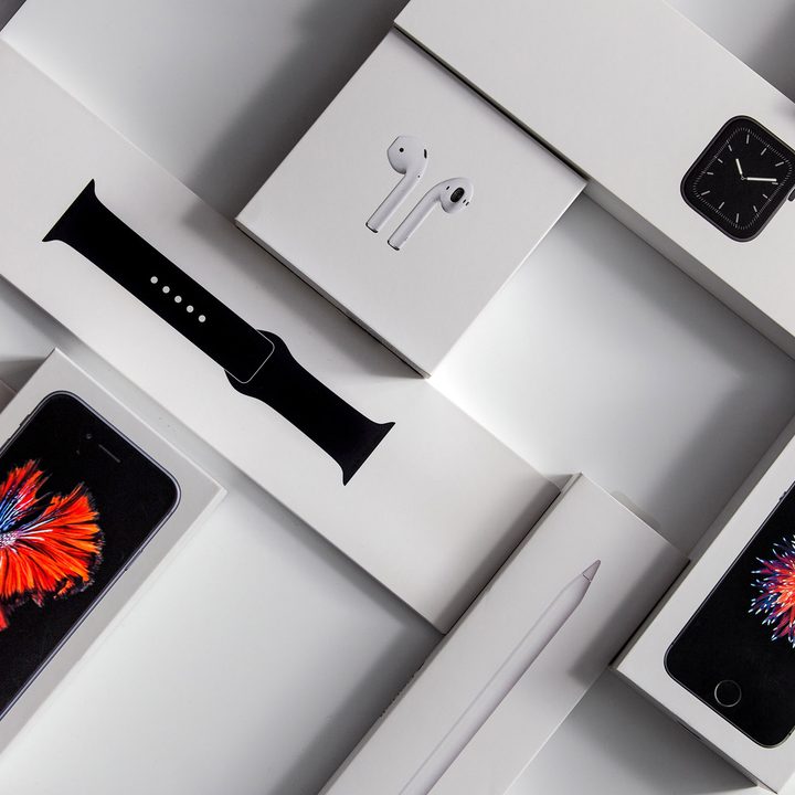 Boxes for an Apple Watch, iPhones, and Airpods sit on a desk.