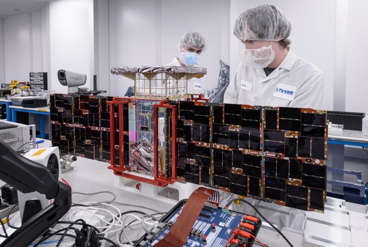 Team members install solar panels onto the CAPSTONE spacecraft – short for Cislunar Autonomous Positioning System Technology Operations and Navigation Experiment – at Tyvak Nano-Satellite Systems Inc.,in Irvine, California.