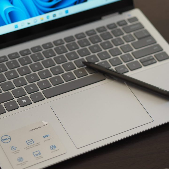 Dell Inspiron 14 2-in-1 7420 top down view showing keyboard, touchpad, and pen.