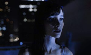 A woman stands outside in a city inImmortality.