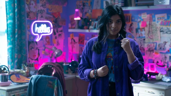 Iman Vellani as Kamala Khan stands in her room, making a fist, in a scene from Ms. Marvel.