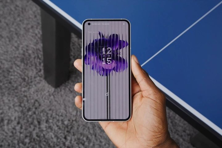 Someone holding the Nothing Phone 1, showing the front of it and its display.